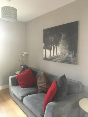a living room with a gray couch with red pillows at Victorian Church Flat 3 in Oswestry
