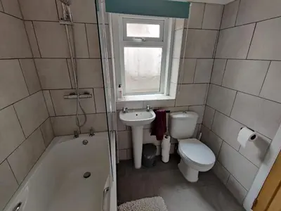 a bathroom with a tub and a toilet and a sink at Llwynygog Guest House in Aberystwyth