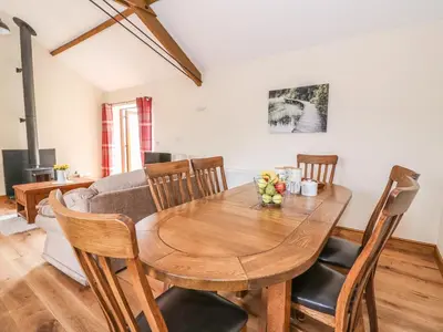 a dining room with a wooden table and chairs at Pentre Fach in Llanddewi Ystradenny