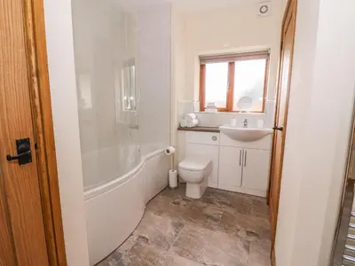 a bathroom with a tub and a toilet and a sink at Pentre Fach in Llanddewi Ystradenny