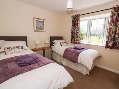 a bedroom with two beds and a window at Pen Y Maes in Builth Wells