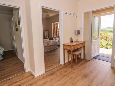 a room with a desk and a bedroom with a bed at Tegfan in Rhayader