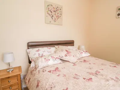 a bedroom with a bed with pink flowers on it at Tegfan in Rhayader