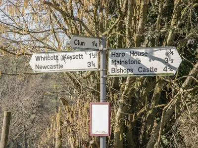 a street sign with street signs on a pole at Bicton Cottage in Acton