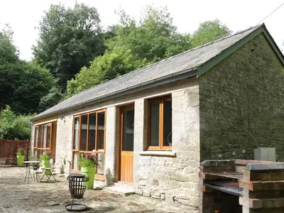 a small stone cottage with a large window at Woodpecker Cottage in Ludlow