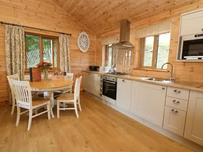 a kitchen and dining room with a table in a cabin at The Firs in Llanidloes