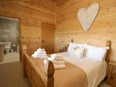 a bedroom with a bed with a heart on the wall at The Firs in Llanidloes