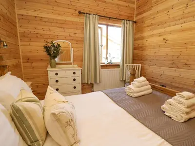 a bedroom with a bed in a wooden room at The Firs in Llanidloes