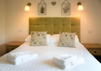 a bedroom with a bed with two towels on it at Llety Ceiro Guesthouse in Aberystwyth