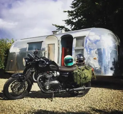 a motorcycle parked in front of a trailer at Ludlow Vintage Airstream in Ludlow