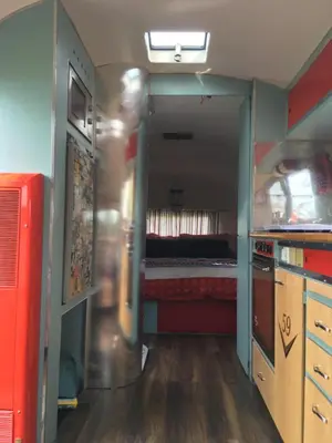 a small room with a kitchen and a bed at Ludlow Vintage Airstream in Ludlow