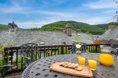 a table with a tray of food and two glasses of orange juice at 3 Bed in Machynlleth oc-bow43 in Corris