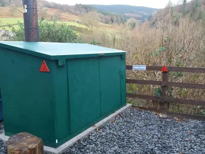 a green dumpster on a fence with two red arrows at 3 Bed in Machynlleth oc-bow43 in Corris
