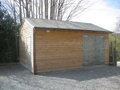 a large wooden garage with a large door at The Horseshoe Guesthouse in Rhayader