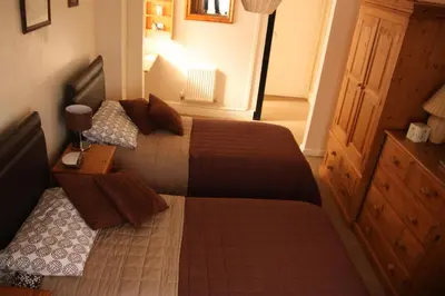 a small bedroom with two beds and a dresser at The Horseshoe Guesthouse in Rhayader