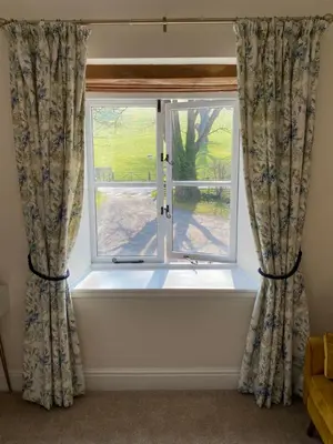 a window with curtains with a view of a yard at Black Mountain Lodge in Glasbury