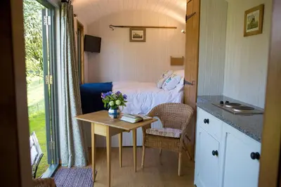 a small room with a bed and a table at GoldenValley Shepherd's Hut in Dorstone