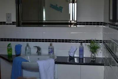 a bathroom with a sink and a mirror and towels at Smithfield Farm Bed & Breakfast in Builth Wells