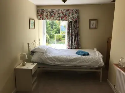 a bedroom with a bed and a window at Pen y Crug Cottage in Llanafan-fawr