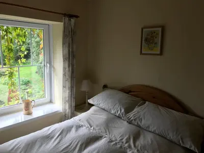 a bedroom with a bed and a window at Pen y Crug Cottage in Llanafan-fawr