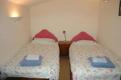 a bedroom with two beds with blue and white sheets at Neuadd Arms Hotel in Llanwrtyd Wells