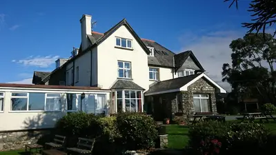 a white house with large windows at Cadwgan House in Dyffryn