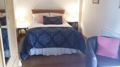 a bedroom with a blue and white bed with pillows at The Granary in Talgarth