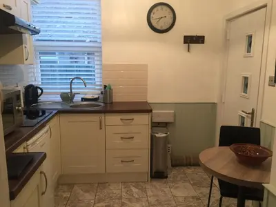 a kitchen with a sink and a clock on the wall at The Flat Frank Lewis House in Hay-on-Wye