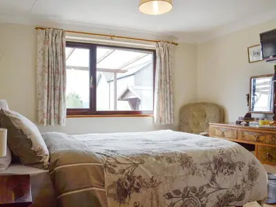 a bedroom with a bed and a window at Three Views Bungalow in Talgarth