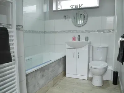 a white bathroom with a toilet and a sink at Lle Clyd in Harlech