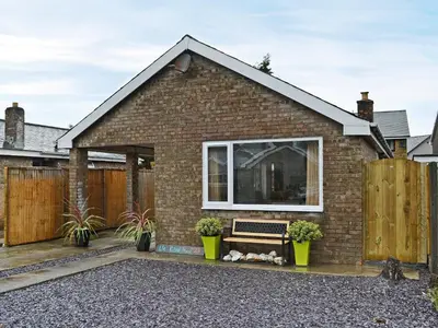 a brick house with a bench in front of it at Lle Clyd in Harlech