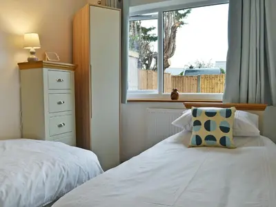 a bedroom with a white bed and a window at Lle Clyd in Harlech