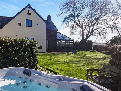 a bath tub in the yard of a house at Green Lane Cottage in Newtown