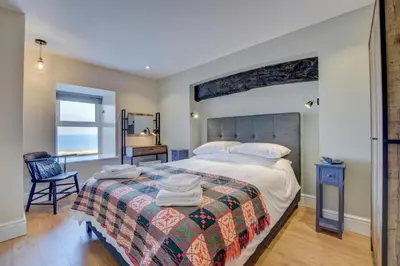 a bedroom with a large bed and a desk at 2 Bed in Barmouth oc-bow52 in Llanaber