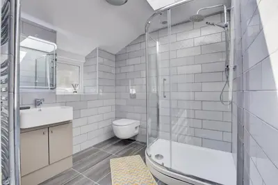 a bathroom with a shower and a toilet and a sink at 2 Bed in Barmouth oc-bow52 in Llanaber