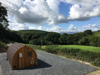 a wooden hobbit house on the side of a road at Cil y Coed Luxury Pod in Machynlleth