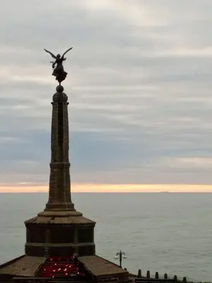 a statue on top of a monument in front of the ocean at Bryn Awel in Aberystwyth
