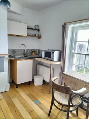 a small kitchen with a table and a microwave at Bryn Awel in Aberystwyth