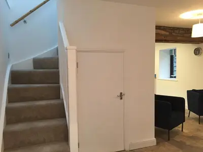 a stairway with a door leading up to a set of stairs at Ty Glo Cottage in Brecon