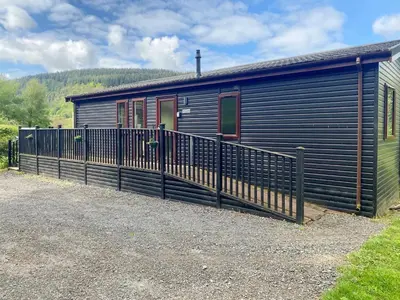 a blue house with a fence next to it at Wye Lodge in Aberedw