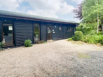 a house with a gravel driveway in front of it at Edw Lodge in Aberedw