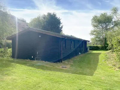 a large black building in a field of grass at Edw Lodge in Aberedw