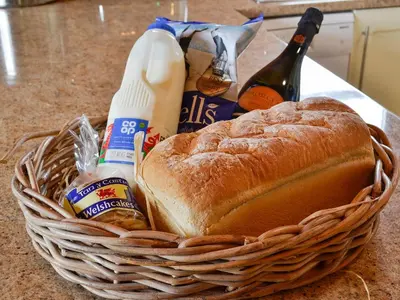 a basket of bread and bottles of beer and a sandwich at Edw Lodge in Aberedw