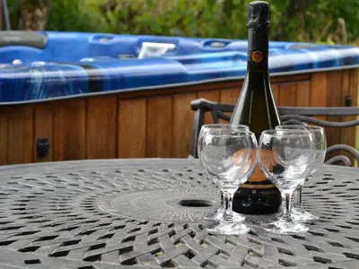 a bottle of wine sitting on a table with two wine glasses at Edw Lodge in Aberedw
