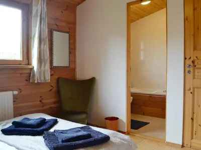 a bedroom with a bed and a bathroom with a tub at Edw Lodge in Aberedw