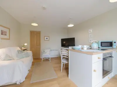 a kitchen and living room with a couch and a microwave at Mortimer Trail Mews in Aymestrey