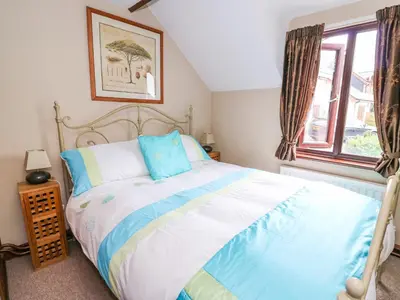 a bedroom with a bed and a window at Cedar Cottage in Llanidloes