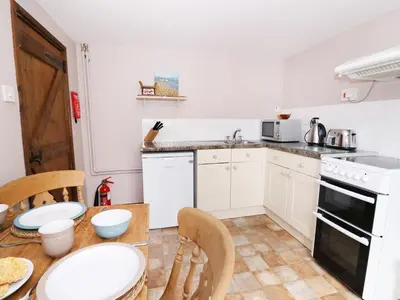 a kitchen with a table and chairs and a stove and oven at Beech Cottage in Llanidloes