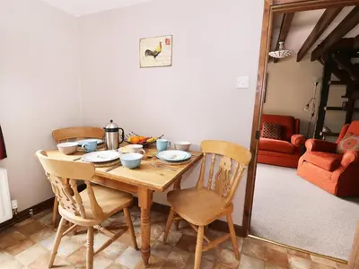 a dining room table with four chairs and a table at Beech Cottage in Llanidloes