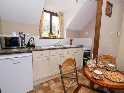 a small kitchen with a table and a sink at Oak Cottage in Llanidloes